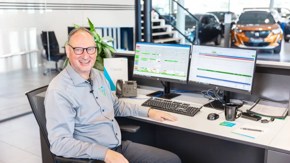 Frontoffice medewerker achter zijn bureau 